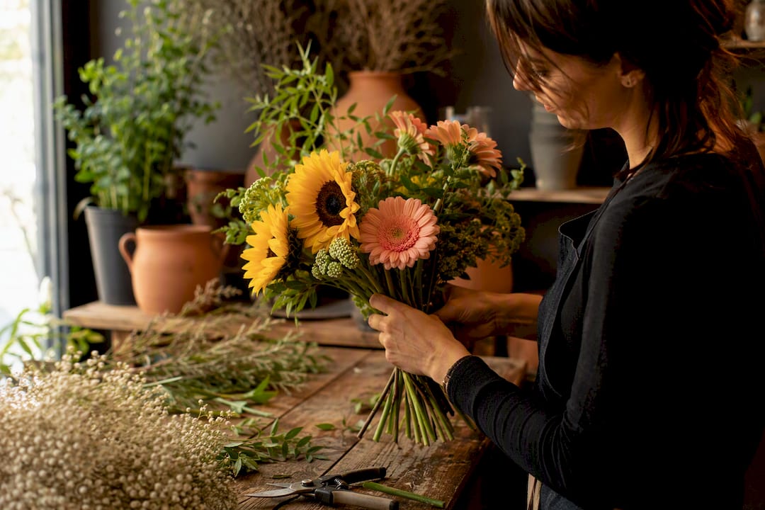 Florist hands arranging cat safe flower bouquet