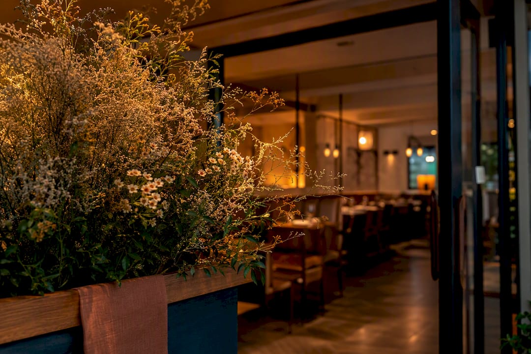 Cropped floral arrangement at restaurant entrance